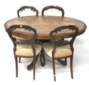 A Victorian walnut inlaid oval loo table and a set of four walnut dining chairs.