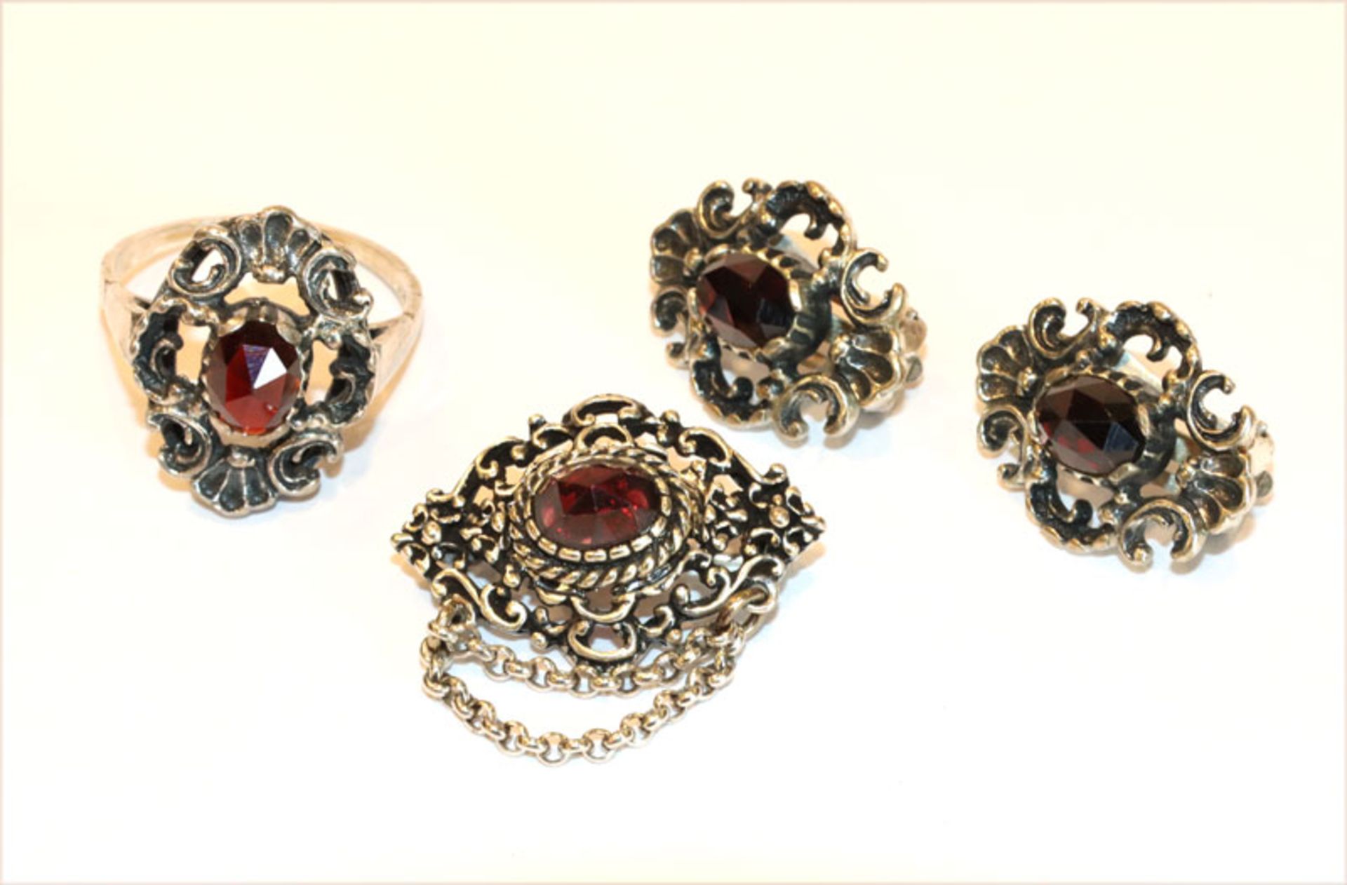 Silber Trachtenschmuck: Ring, Gr. 62, Brosche, B 3 cm, und Paar Ohrclips, alles mit Granaten, zus.