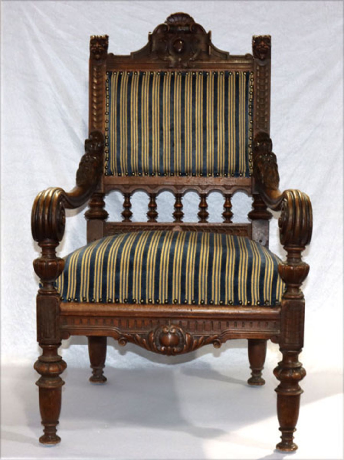 Armlehnstuhl, reich beschnitzt und teils gedrechselt, Sitz und Lehnen gepolstert und blau/gelb