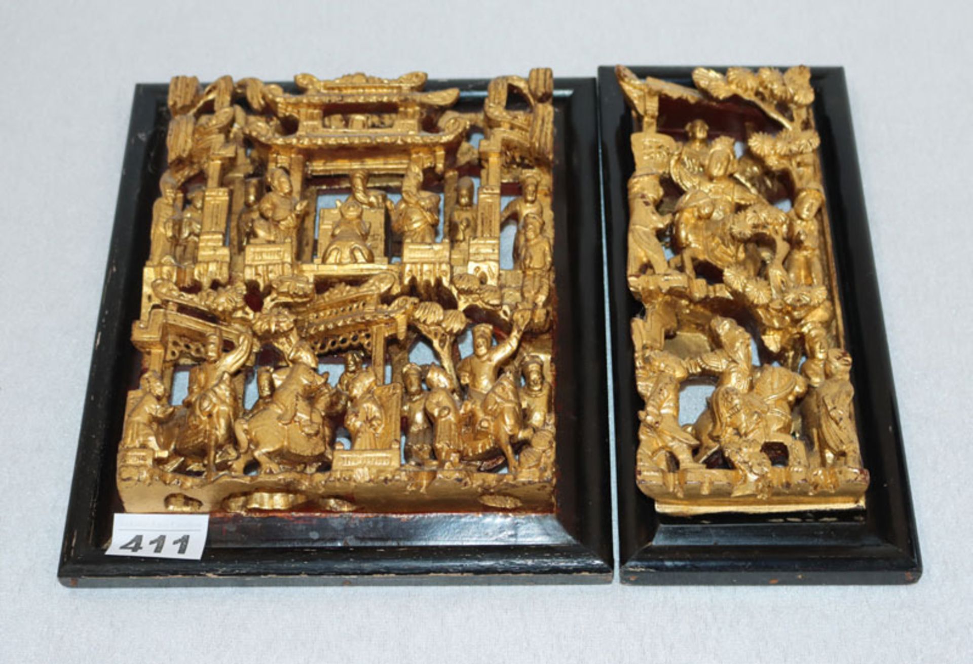 2 asiatische Holzornamente mit plastischer Figurenschnitzerei, gold gefaßt in schwarzen Rahmen, 26,5