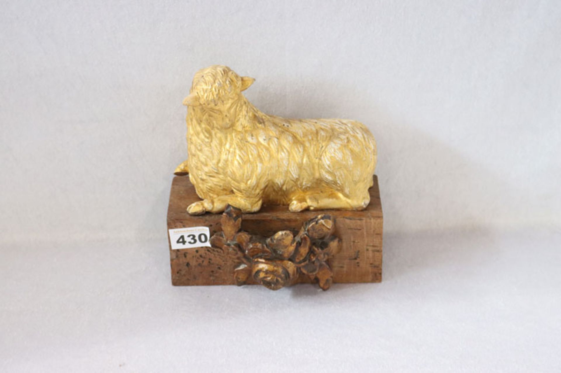 Holzskulptur 'Lamm Gottes', 19. Jahrhundert, gold gefaßt auf Holzsockel mit Blumendrelief, teils
