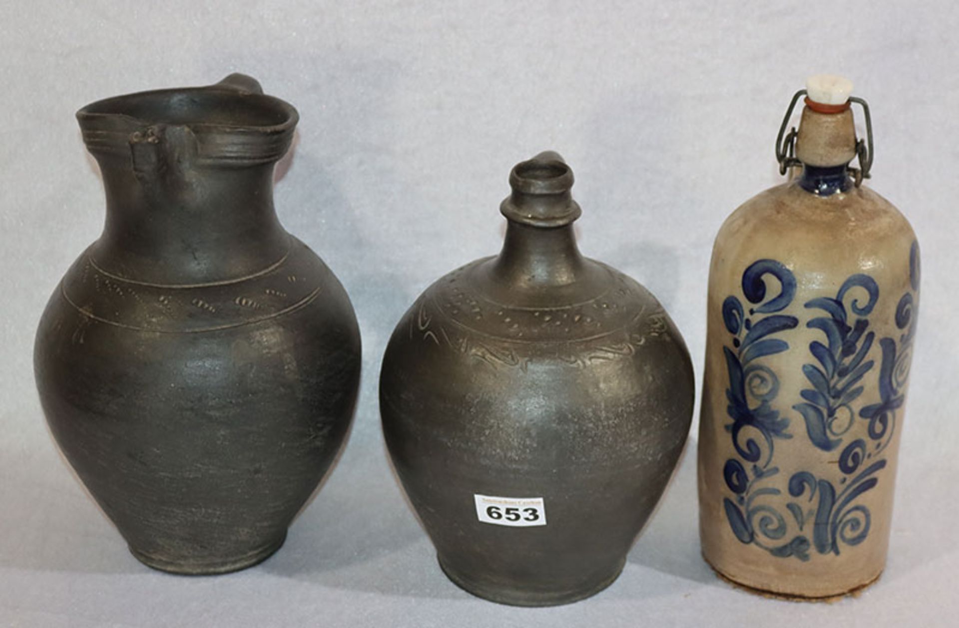 Konvolut: 2 Keramik Henkelkrüge, dunkelbraun mit Ritzdekor, 26/29 cm, un Steingut Flasche mit blauem