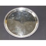 A plain George III circular silver salver with knurled rim, on three bracket feet - ID, London 1807,