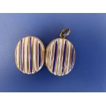 An oval gold back & front enamelled locket decorated blue & white stripes, 1.1" overall - some