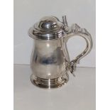 An early George III silver tankard, the tulip shaped body bearing engraved cartouche with three