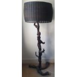 An antique oriental lamp with iron basketwork shade on rootwood base, 60" overall height.