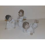 Three Lladro figures depicting young male angels, the tallest 5.25".