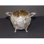 A late 19thC continental silver two-handled repousse sugar bowl, decorated putti and flowers -