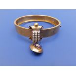 A Victorian gold bangle of plain Etruscan design, set with seed pearls and oval drop locket, dark
