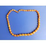 A moulded butterscotch amber graduated bead necklace, the largest bead 16mm, necklace length 20" -