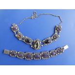 An ornate silver bracelet set with large carved amethysts - the largest approximately 17mm across,