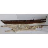 A 19thC wooden model of a canoe with two sails, 46" across.