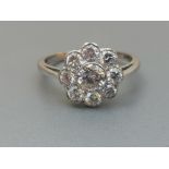 A diamond cluster ring, the nine brilliant cut stones millegrain set in 18ct white gold. Finger size