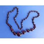A graduated faux amber faceted bead necklace, of transparent reddish colour, the largest bead