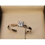 A modern diamond solitaire, the four-claw set brilliant cut stone weighing approximately 0.25 carat,