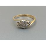 A small diamond cluster ring in crossover setting on '18ct' shank. Finger size G/H.