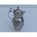 A small silver lidded jug, embossed floral swags to sides - London import marks for 1902, 3.7"