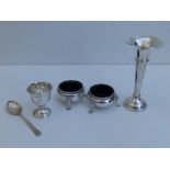 A pair of silver salts with liners, a spill vase, a napkin ring and an egg cup with spoon. (6)