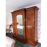 A Victorian mahogany triple section breakfront wardrobe, the ogee moulded cornice above a round-arch