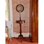 A Victorian mahogany tripod shaving stand, the circular table opening with two hinged covers to