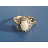 An opal & diamond oval cluster ring in 18ct gold - London marks. Finger size O.