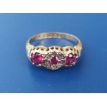 An Edwardian ruby & diamond set 18ct gold ring, set with three circular rubies and a central cluster