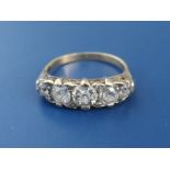 An early 20thC five stone graduated old cut diamond ring, the central claw set stone weighing