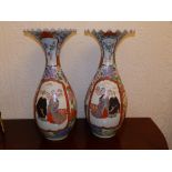 A large pair of 19thC Japanese porcelain vases, the wide flared frilled rims onto slender necks,