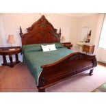 A Victorian style mahogany king size double bed, the high arched headboard with carved panelled