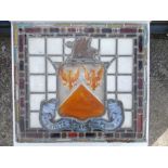 A pair of Victorian stained leaded light window panels, each with a shield surmounted by a griffin