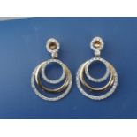 A pair of modern hoop earrings set with numerous small diamonds, 1.1" (2)