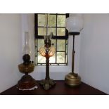 A Victorian brass oil lamp with moulded glass reservoir, 26" high overall and two others. (3)