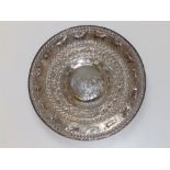 An Eastern silvered metal circular dish, decorated elephants, other animals & birds, 12" diameter.