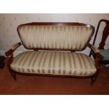 A Victorian upholstered settee, having padded elbow rests to the open arms, on turned tapering front