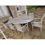 A modern weathered teak garden table and eight carver chairs, the table 94". (9) Separate viewing