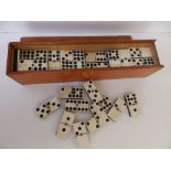A boxed set of ebony & bone dominoes.