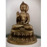 An Eastern brass figure of a seated Buddha.
