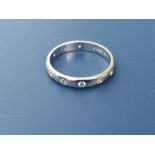 A modern 18ct white gold band set with 12 small diamonds. Finger size L.