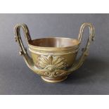 A 19thC Classical Revival bronze two-handled cup, having anthemion decoration, 5" across the high