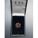 A boxed Garrard & Co. amethyst & diamond set 18ct gold flower brooch/pendant, a carved amethyst