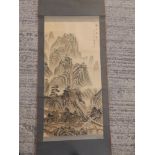 A 20thC signed Chinese watercolour scroll depicting travellers in a mountainous landscape, image