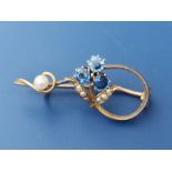 A sapphire & pearl set 15ct brooch in the form of a small scrolling flowerhead, 1.3".