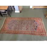 An Oriental stepped medallion pattern rug, principally in red & blue, 10ft x 4ft10ins - a/f.