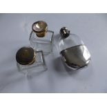 A pair of silver gilt top glass toiletry bottles together with an EP mounted hip flask. (3)