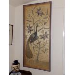 A 20thC metal thread & stumpwork embroidered panel depicting a peacock perched on a flowering plant,