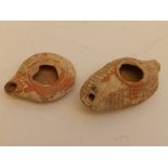 Two small Roman pottery oil lamps, the larger 4.25" across.