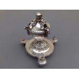 A 19thC silver plated table-top cigar lighter/stand, of urn form having three mask holders for