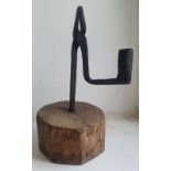 A wrought iron rush light holder, on wooden base,, 8" overall height.
