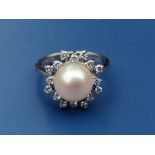 A pearl & diamond set cluster ring on 750 white metal shank. Finger size L.