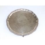 A silver salver, having shaped tied reeded rim, on four pad feet - Barker Brothers, Chester 1914,